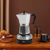 A moka pot coffee maker with coffee beans and a croissant on a wooden table. Produktbild-Vorschau
