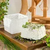 A cheese mold and a block of cheese seasoned with herbs and spices on a wooden board. Produktbild-Vorschau