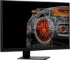 A wireframe rendering of a sports car with orange wheels is displayed on a black background, reflected on a surface below. The monitor itself is black with the OMEN logo visible on the bottom bezel. Podgląd zdjęcia produktu