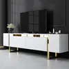A modern white TV stand with gold accents, featuring a large flat-screen television on top, set against a dark gray wall. Náhľad obrázku produktu