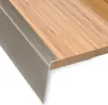 A close-up view of a stair nosing profile installed on a wooden surface. Podgląd zdjęcia produktu