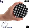 A hand holding a jar lid with a black and white checkered pattern. Anteprima dell’immagine prodotto