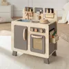 A wooden toy kitchen is set up in a child's room, with a white dresser and a bed in the background. Podgląd zdjęcia produktu