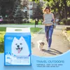 A woman walks her dog in a park, with a package of pet pads in the foreground. Produktbild-Vorschau
