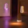 Two RGB night lights are mounted on walls, casting colored light onto a wooden floor. Náhled obrázku produktu