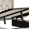 Close-up view of the internal mechanism and slatted base of a bed frame, with a portion of the upholstered headboard visible. Produktbild-Vorschau