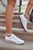 Two people walking up stairs, focusing on their white sneakers. Voir les images du produit