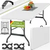 A white folding table is shown, set up and decorated with a bowl of fruit and a plant. The table has a banner attached to its legs with German text and colors. Several accessories are also displayed around the table, including a folded table, a carrying ha