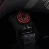 A close-up view of the interior of a helmet, showing a buckle and a red pull tab. Anteprima dell’immagine prodotto