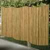 A bamboo privacy screen is shown in an outdoor setting, attached to a metal fence. Náhled obrázku produktu