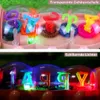 Rosa Raupenspielzeug mit transparenter Hülle, die bunte Zahnräder und Buchstaben im Inneren zeigt, beleuchtet von blendenden Lichtern Anteprima dell’immagine prodotto
