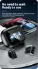 A pair of black wireless earbuds and their charging case are displayed on a circular, textured surface, with a smartphone in the background. Produktbild-Vorschau