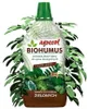 A bottle of Biohumus fertilizer for green plants, surrounded by green leaves. Podgląd zdjęcia produktu