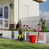 A backyard scene with raised garden beds, gardening tools, and a pressure washer. Voir les images du produit