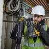 A construction worker using a rotary hammer drill. Produktbild-Vorschau