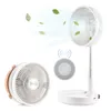 A white portable fan is shown in two configurations: folded and extended. Green leaves are depicted floating in the air around the extended fan, suggesting airflow. A circular remote control with wireless signal icons is also shown. Náhľad obrázku produktu
