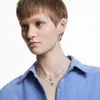 A close-up shot of a woman wearing jewelry, including necklaces and earrings. Produktbild-Vorschau