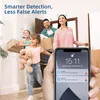 A family is moving into a new home, carrying boxes. A hand holds a smartphone displaying notifications from a security camera. Produktbild-Vorschau