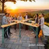 People enjoying drinks and snacks at a folding table outdoors during sunset. Produktbild-Vorschau