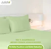 A bed with green sheets and pillows, with a bedside lamp and a wall lamp. Produktbild-Vorschau