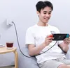 A young man is playing a Nintendo Switch while it is charging. Anteprima dell’immagine prodotto