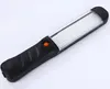 A black and clear LED work light with an orange button is shown on a white background. Voir les images du produit