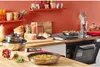 A kitchen counter with various cooking items, including pots, pans, and ingredients. Voir les images du produit
