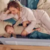 A mother and baby are lying on a bed with a bed rail. Anteprima dell’immagine prodotto
