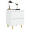 A white bedside table with two drawers, a black and gold lamp, a book, and a small plant in a vase. Náhled obrázku produktu