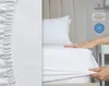 A hand is shown pulling a white fitted sheet over a mattress. Produktbild-Vorschau