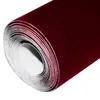 A roll of maroon velvet fabric on a white background. Produktbild-Vorschau