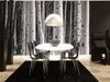 A dining set with a white oval table and chairs in front of a birch tree wallpaper. Produktbild-Vorschau