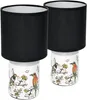 Two table lamps with black shades and ceramic bases decorated with Asian-style birds and flowers. Produktbild-Vorschau
