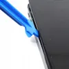 A blue plastic tool is being used to pry open the edge of a black electronic device, likely a smartphone. Produktbild-Vorschau