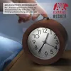 A hand is pressing the snooze button on a wooden alarm clock. Náhľad obrázku produktu