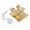 A golden colored 4-cylinder Stirling engine model with a white cord and a white LED bulb attached. Produktbild-Vorschau