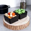Two black ceramic bowls filled with snacks, placed on a wooden stand. Voir les images du produit