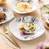 A table setting with multiple plates of food and a glass of water. Produktbild-Vorschau