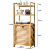 A bamboo shelving unit with a laundry basket compartment, shown with various bathroom items and towels. Produktbild-Vorschau