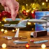A hand is placing a model spaceship onto a stand, with a Christmas tree and lights in the background. Podgląd zdjęcia produktu