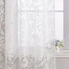 A close-up view of white sheer curtains with a damask pattern hanging in front of a window. Produktbild-Vorschau