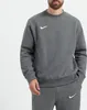 A man wearing a dark gray Nike pullover and matching sweatpants. Produktbild-Vorschau