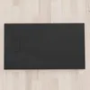 A black rectangular shower tray is shown from a top-down perspective, placed on a light-colored wooden floor. Produktbild-Vorschau