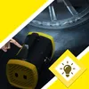 A hand is shown pressing a button on a black and yellow portable air compressor, with a car tire in the background. A yellow diamond shape with a lightbulb icon is in the lower right corner. Produktbild-Vorschau