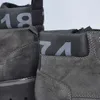 Close-up view of two grey Rieker boots, showing details of the stitching, branding, and numerical accents. Náhled obrázku produktu