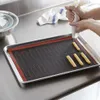 A person is using a piping bag to create pastry shapes on a baking mat on a baking sheet. Podgląd zdjęcia produktu