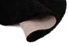 A close-up view of a black rug, showing the texture of the pile and the backing. Voir les images du produit