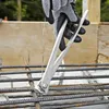 A gloved hand uses wire cutters to cut wire around rebar. Produktbild-Vorschau