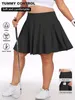 A woman is modeling a black tennis skirt and holding a golf club. Produktbild-Vorschau