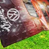 A close-up of a blanket with a car graphic and grass in the foreground. Produktbild-Vorschau